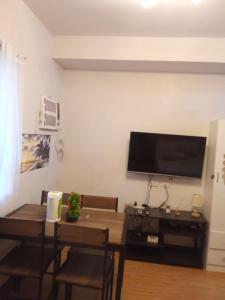 a living room with a table and a flat screen tv at Lois Ann Condo in Pontud