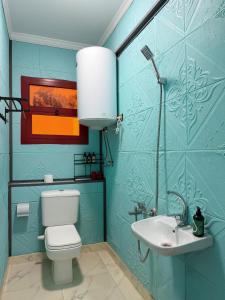 a blue bathroom with a toilet and a sink at JubingeHotel 聚滨阁华人酒店 in Cairo +7 photos