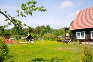 a yard of a log cabin with a house at Baurine Puhkemaja in Aseri
