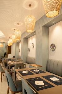 a dining room with tables and chairs and chandeliers at Yadis Hammamet in Hammamet