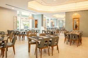 a restaurant with tables and chairs and windows at Yadis Hammamet in Hammamet
