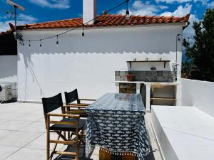a patio with a table and chairs on a roof at Aloni Petit House in Nerotriviá