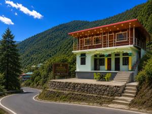 a house on the side of a winding road at Harshil Pinewood Homestay in Harsil
