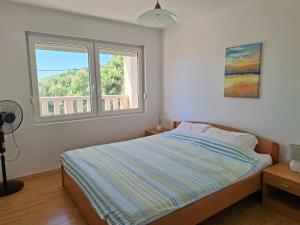 a bedroom with a bed and a window at Sea View Apartments in Selca
