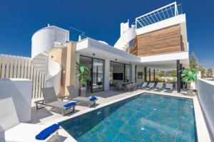 a villa with a swimming pool and a house at Aqua Pearl Villas in Protaras