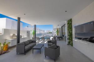 a living room with couches and chairs and a table at Aqua Pearl Villas in Protaras