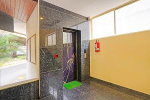 a bathroom with a shower with a glass door at FabHotel Pride - Electronic City in Bangalore +22 photos