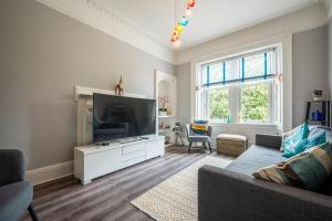 a living room with a couch and a flat screen tv at Culzean Road, Retreat in Maybole