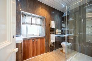 a bathroom with a glass shower and a toilet at Culzean Road, Retreat in Maybole +18 photos