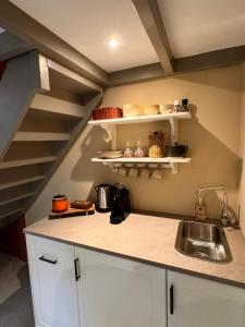 a kitchen with a sink and a staircase at New monumental garden view Studio in Amsterdam