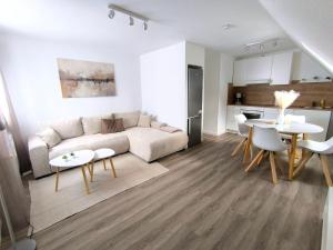 a living room with a couch and tables and a kitchen at Ferienwohnung-Heide-3 in Walsrode