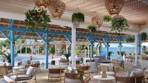 a restaurant with tables and chairs and a pool at Veranda Pointe Aux Biches Hotel & Spa in Trou aux Biches