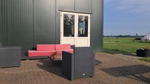 a couch and speakers in front of a building at Studio Rozenbottel shared bathroom in Hensbroek +2 photos