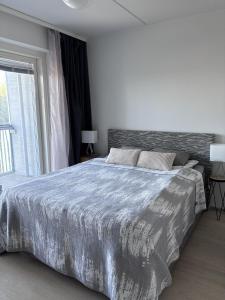 a bedroom with a large bed and a window at Modern studio next to Finnoo metro - Tuohi BossHomes in Espoo