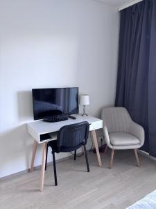 a desk with a computer and a chair in a room at Modern studio next to Finnoo metro - Tuohi BossHomes in Espoo