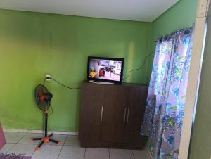 a living room with a television and a fan at cantinho do descanso in Dourados