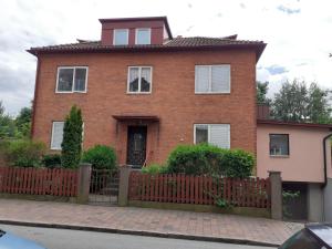 a red brick house with a wooden fence at Honeymoon Guesthouse in Helsingborg
