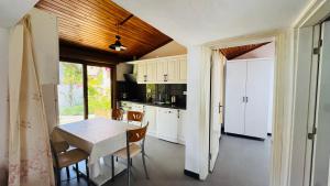 a kitchen with white cabinets and a table and chairs at Tomsan Villas Akyaka in Akyaka