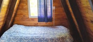 a small bedroom with a bed and a window at Cabaña Capitán Viruta in Rosario