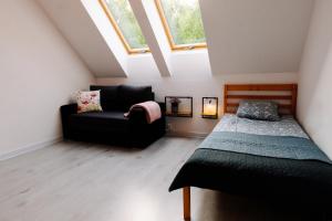 a attic room with a bed and a couch at 4 Pory Roku in Darłowo +76 photos