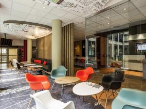 a lobby with colorful chairs and tables in a building at ibis München Parkstadt Schwabing in Munich