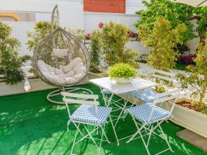 a patio with a table and chairs and a swing at Ideal Rooms in Porto Cesareo