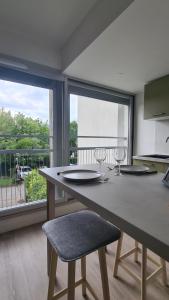 a kitchen with a large table with chairs and a balcony at Studio moderne Climatisé Meylan centre proche CHU in Meylan +4 photos