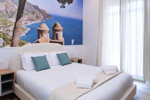 a bedroom with a large white bed with a painting on the wall at Salerno Stay in Salerno