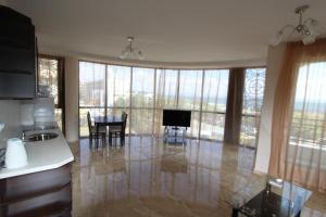 a kitchen and living room with a table and chairs at goldenseaview in Pomorie