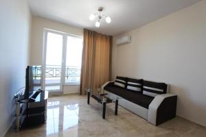 a living room with a couch and a table at goldenseaview in Pomorie