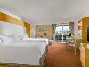 a hotel room with two beds and a desk at Sofitel Cairo Nile El Gezirah in Cairo +113 photos