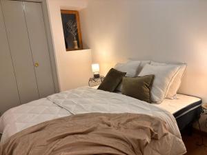 a bedroom with a bed with white sheets and pillows at Le Roche-Velours in Paray-le-Monial
