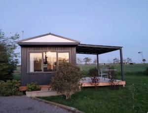 a tiny house in the middle of a field at Farmstay in Elingamite North