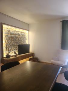 a room with a table and a tv and chairs at Le Roche-Velours in Paray-le-Monial +8 photos