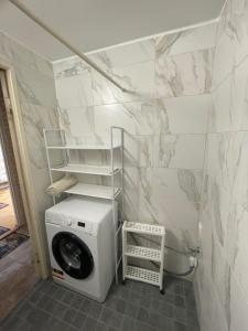 a bathroom with a washing machine in a room at Frendlen Papiniidu Apartment in Pärnu