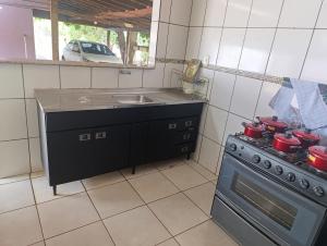 a kitchen with a stove and a sink at cantinho do descanso in Dourados