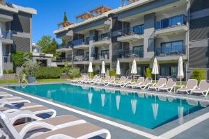 a swimming pool with lounge chairs and a hotel at A Suite Side in Side