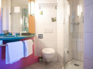 a bathroom with a toilet and a shower at ibis Fribourg in Fribourg +48 photos