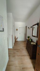 an empty room with a mirror and a wooden floor at Villa Lorelia in La Adrada
