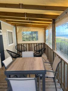 a table and chairs on a porch with a table and chairs at Camping du CONGUEL in Quiberon