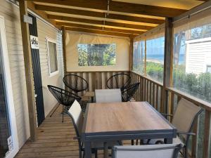 a screened porch with a table and chairs on it at Camping du CONGUEL in Quiberon