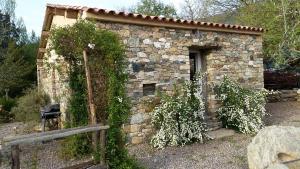 a small stone building with a door and some plants at Domaine Casa Andria in Barbaggio