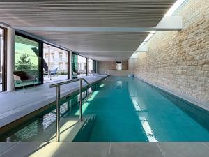 an indoor swimming pool in a building with a brick wall at Coasteres T2 in Trébeurden
