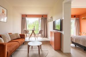 a living room with a couch and a table at Tiny House XL | 2 persons in Gasselte