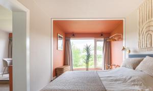 a bedroom with a bed and a large window at Tiny House XL | 2 persons in Gasselte