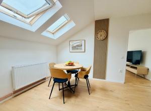 a dining room with a table and chairs and a clock at Apartmán Štúr Trenčín Centrum in Trenčín