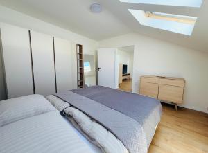 a white bedroom with a bed and a skylight at Apartmán Štúr Trenčín Centrum in Trenčín