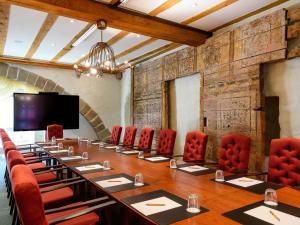 ein großer Konferenzraum mit einem langen Tisch und roten Stühlen in der Unterkunft Mercure Hotel Erfurt Altstadt in Erfurt