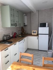 a kitchen with white cabinets and a white refrigerator at Casita la 'Dore in Cariño +33 photos