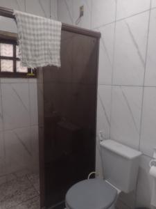 a bathroom with a toilet and a shower with a window at Chalé de família in Mangaratiba